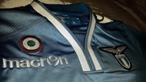 Una maglia della SS Lazio prodotta da Macron con lo stemma della Tim Cup. 