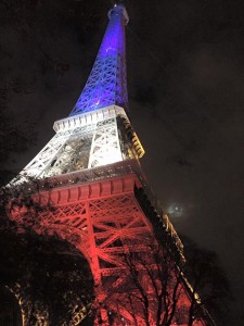 La torre Eiffel illuminata con la bandiera francese
